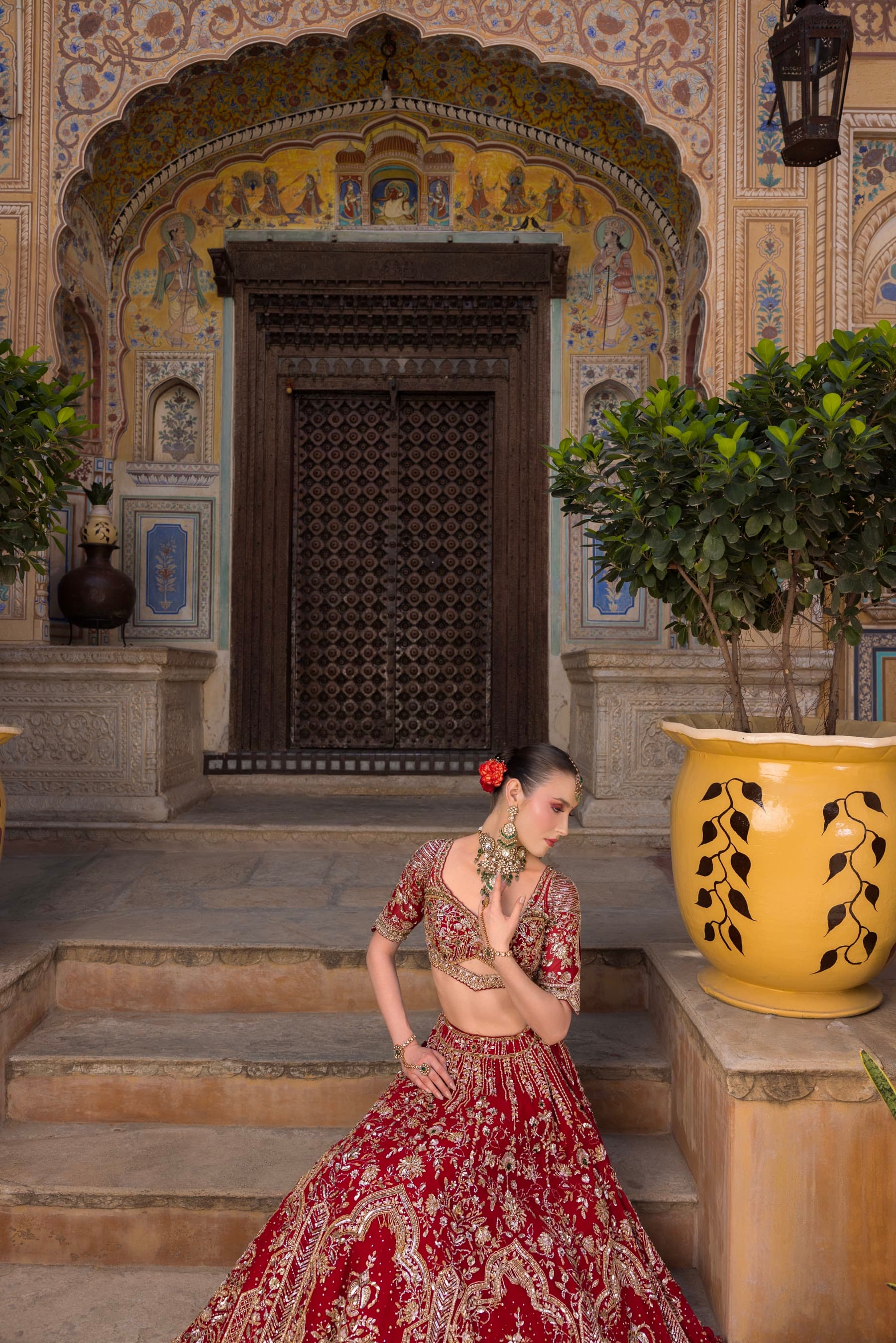 An ornate haveli doorway, the bride small against it