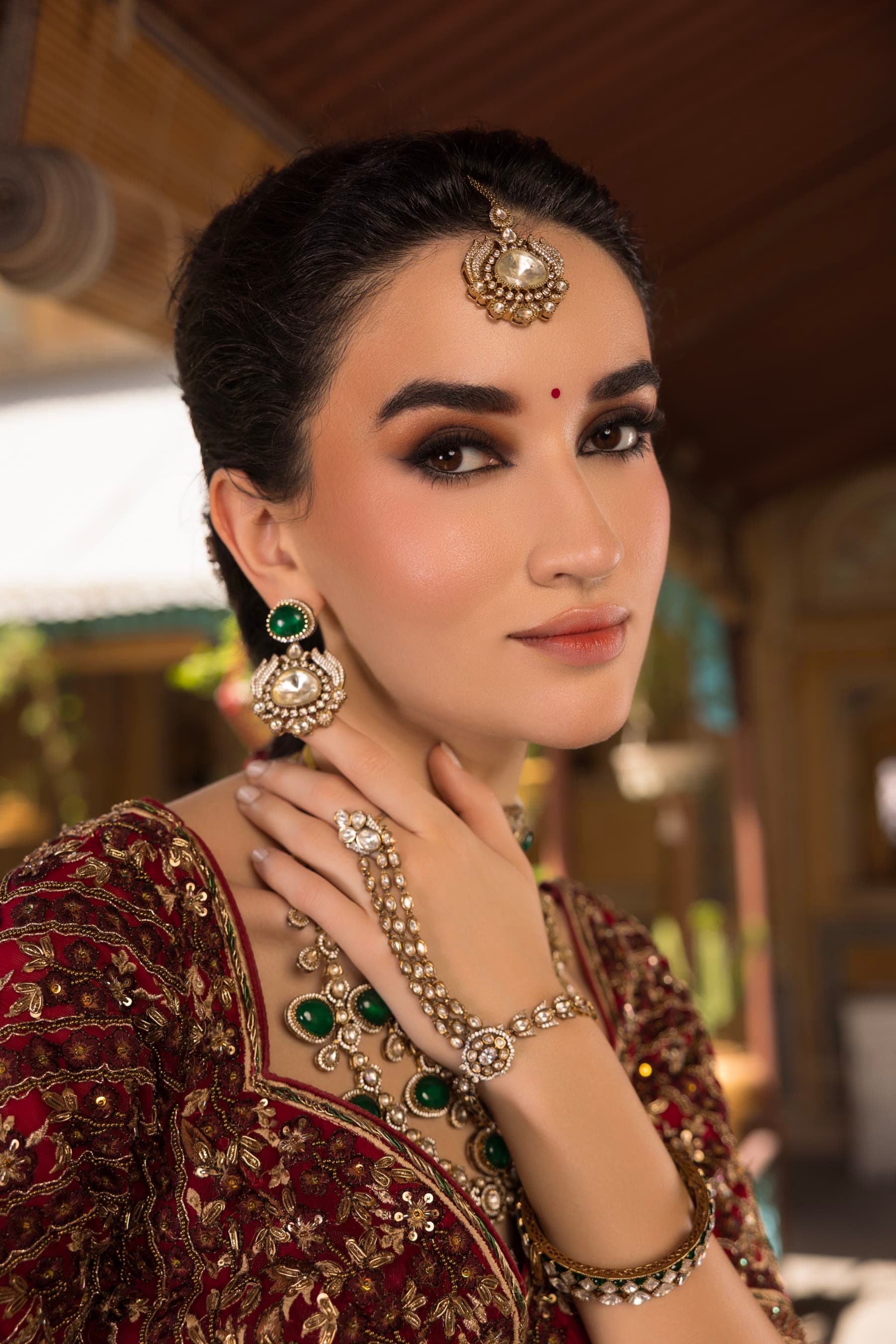 Close portrait: maang tikka, emerald drops, a smoked eye