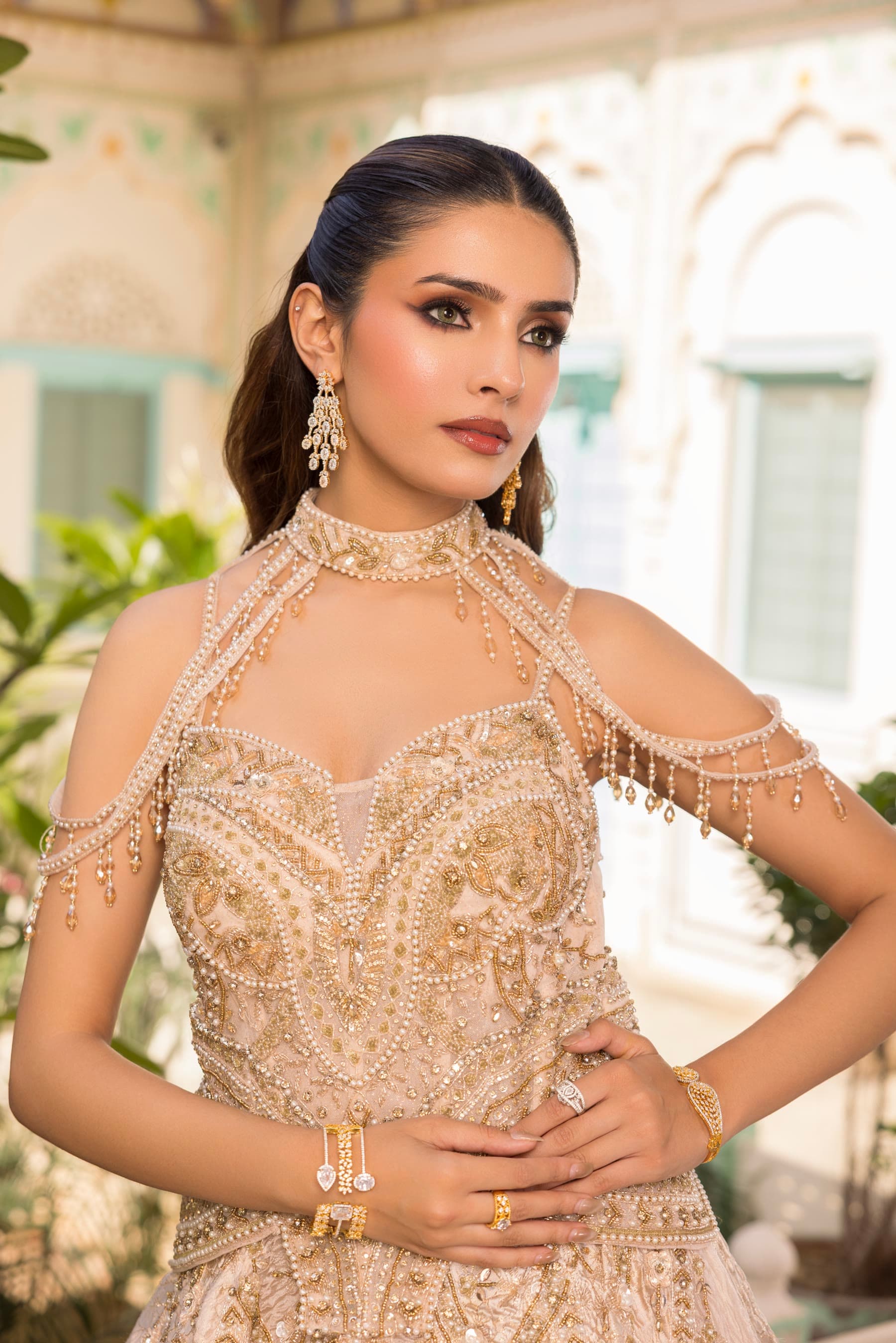 A bride in champagne, both hands at her hips
