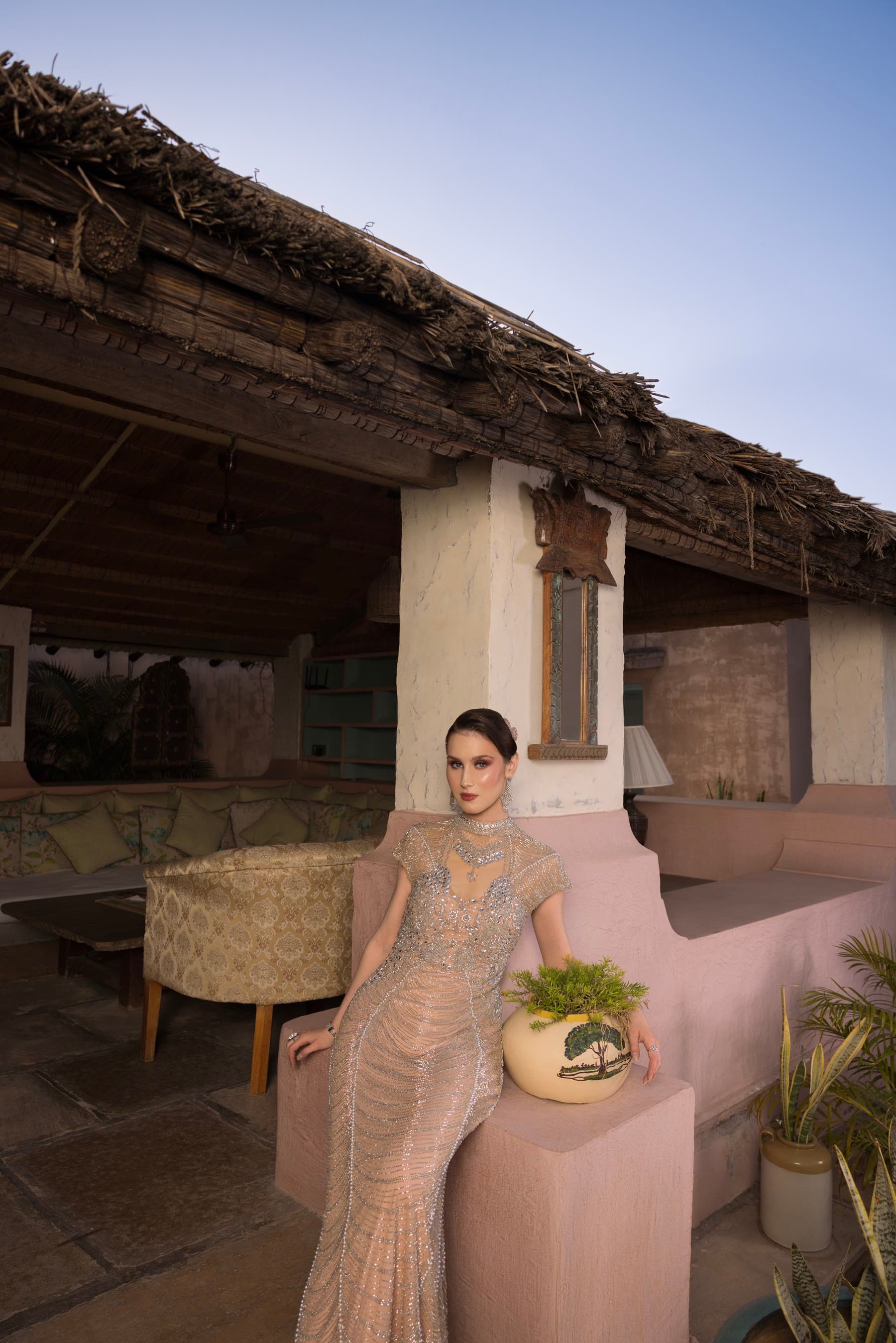 A thatched pavilion at dusk, the bride at the near end