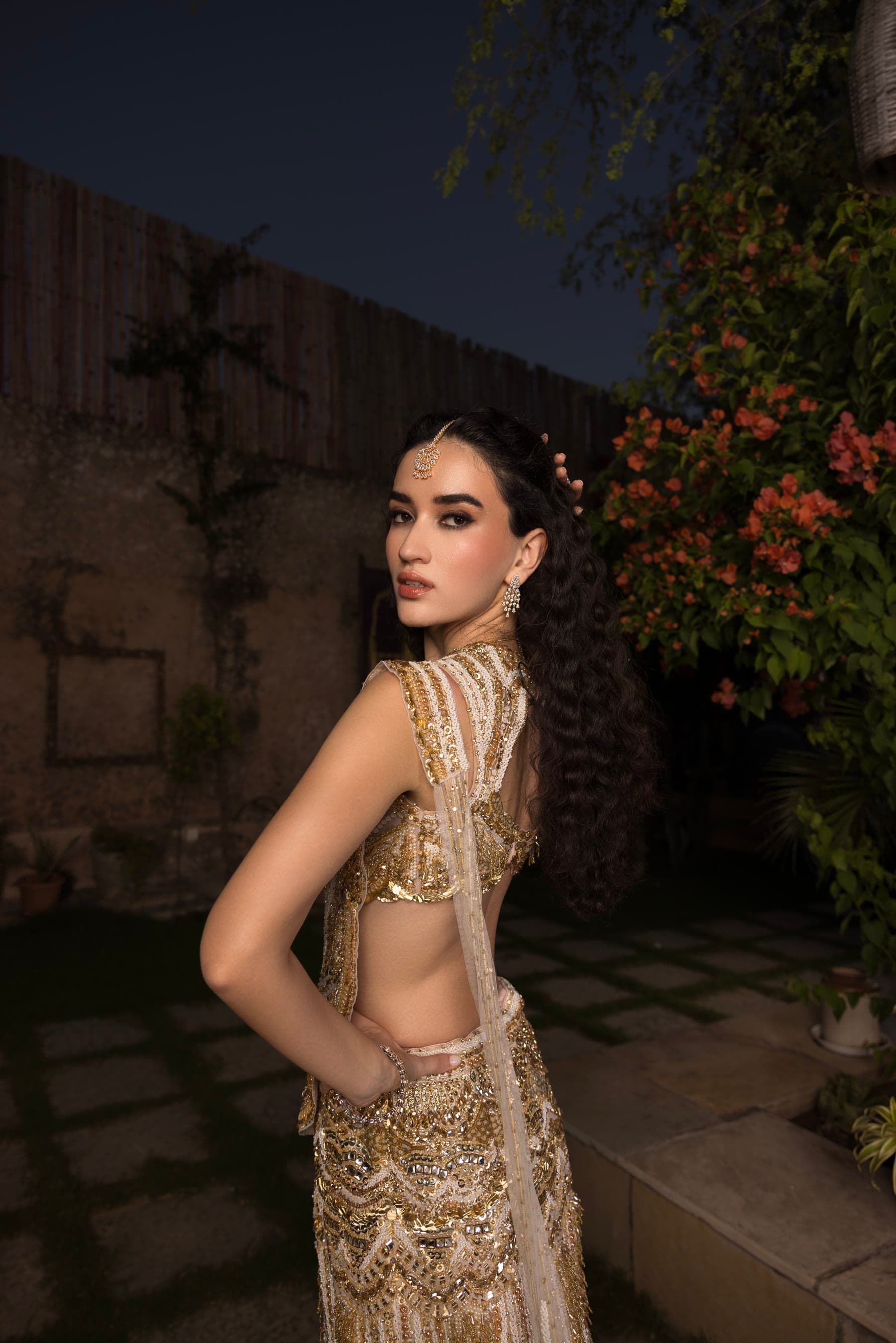 A profile in gold against the dark garden