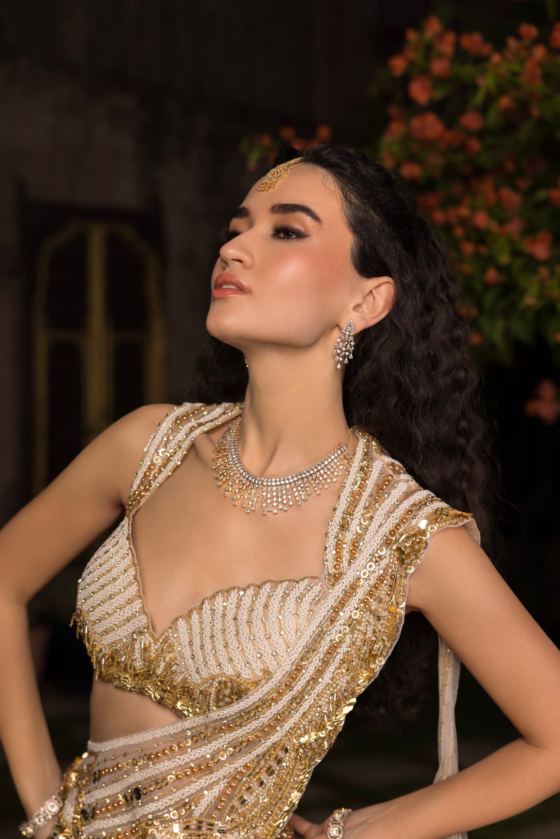 A bride looking upward, one arm at her hip